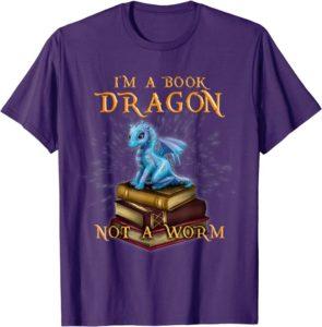  lilafarbenes T-Shirt mit Aufdruck „I'M A BOOK DRAGON NOT A WORM“ und niedlichem blauen Drachen auf einem Bücherstapel