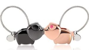 Schlüsselanhänger aus Metall für SIE und IHN: zwei Glücksschweinchen in schwarz und pink mit Magneten in den Rüsseln, so dass sie sich küssen, wenn sie zusammenkommen