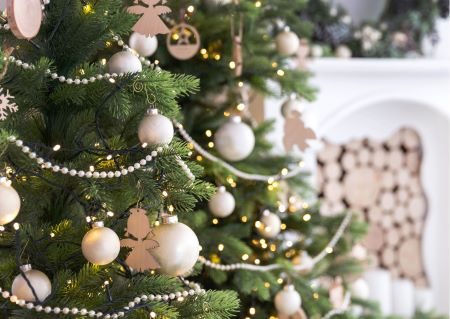 Weihnachtsbaum dekoriert mit beigen Kugeln und Holzanhängern