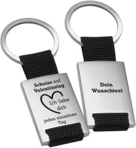 personalisierbarer rechteckiger Edelstahl-Schlüsselanhänger mit schwarzem Textilband und Text: "Scheiss auf Valentinstag - Ich liebe dich jeden einzelnen Tag" mit Herzmotiv – Wunschtext auf der Rückseite
