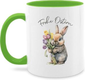 weiße Tasse mit hellgrünem Henkel und Tasseninnerem mit Motiv: Häschen mit Tulpenstrauß und Aufdruck Frohe Ostern