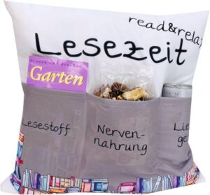 Motiv-Kissen mit Aufdruck: „Lesezeit“ und „read and relax“. in der unteren Hälfte sind drei Taschen aufgenäht für Lesestoff, Nervennahrung und Lieblingsgetränk. 