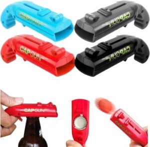 4 witzige "Flaschenöffner Pistolen" in rot, hellblau, grau und schwarz, die den Kronkorken direkt in den Mülleimer "schießen" können – witzige Wichtelgeschenk-Idee für Männer